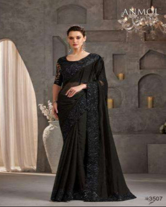 Woman wearing a black saree with intricate designs in a decorative setting.