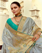 Woman wearing a traditional saree with intricate designs in an elegant setting.