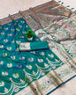 Teal saree with intricate patterns on a beige background