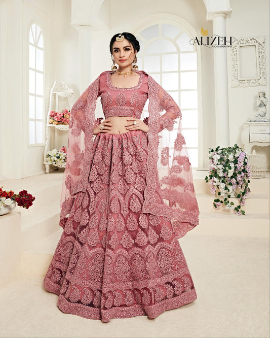Pink traditional outfit with intricate patterns worn by a model in a well-lit room.