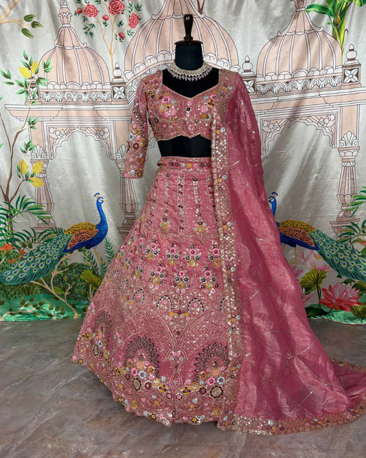Pink embroidered traditional outfit on a mannequin with a decorative background