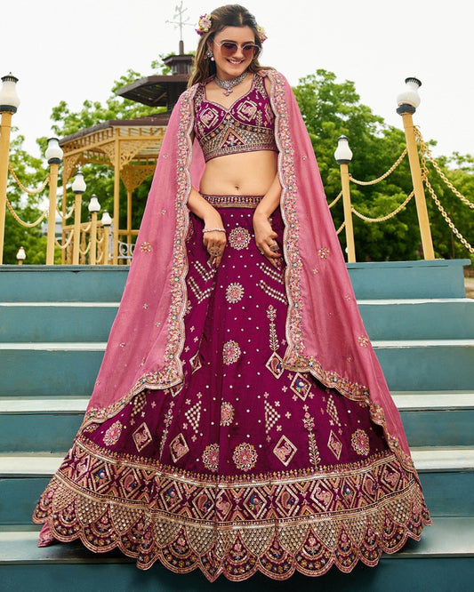 Woman in a traditional purple and pink embroidered outfit standing on steps outdoors.